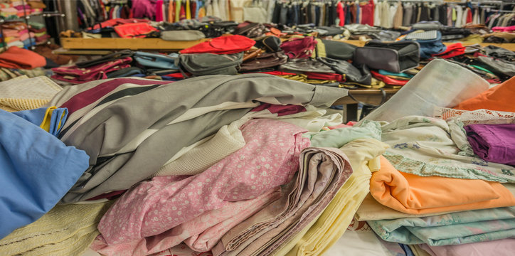 Recycling Verkauf von Secondhand Textilien und Handtaschen auf dem W&uuml;hltisch - Recycling Sale of second-hand textiles and handbags on the rummage table
