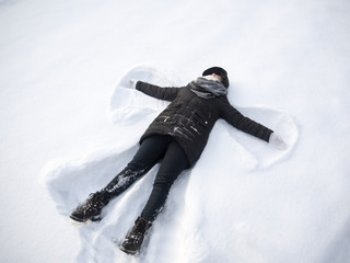 girl shows angel lying in the snow