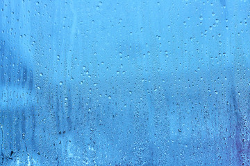 Natural blue water drop background on glass