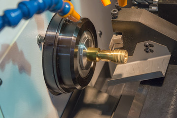 The small CNC lathe cutting the brass shaft thread part.