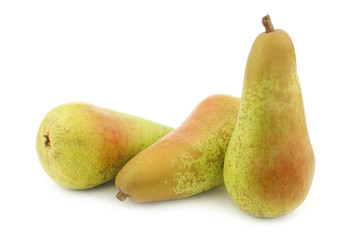 three fresh abate pears on a white background