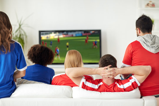 friends or soccer fans watching game on tv at home