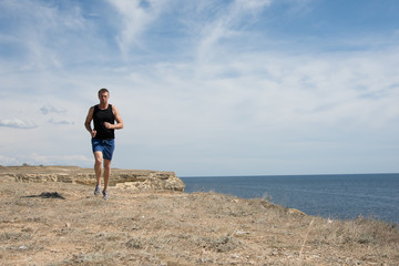Running and a healthy lifestyle. A man runs along the beach. 