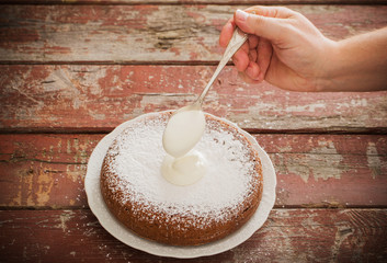 overlaying cream on a sponge cake