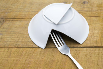 Broken plate on a wooden table.
