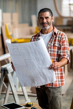 Carpenter holding a blueprint