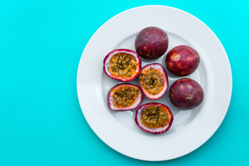 Passion fruit on a white plate on blue napkin Outdoor background