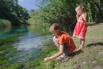 Children playing active game on Tirino river bank in Italian Abruzzo province