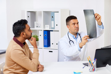 doctor with x-ray and male patient at clinic
