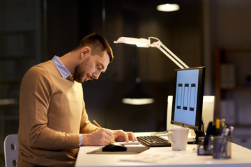man with notepad working at night office
