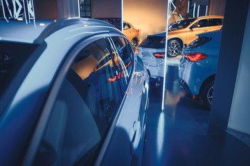 fashionable bright auto show A number of new cars parked in the car dealers' warehouse, modern design of the room with mirrors