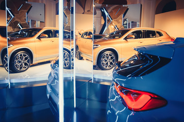 fashionable bright auto show A number of new cars parked in the car dealers' warehouse, modern design of the room with mirrors