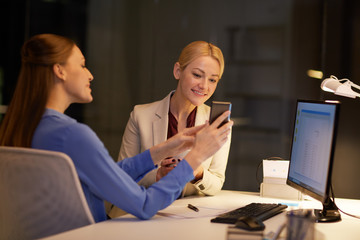 businesswomen with smartphone late at night office