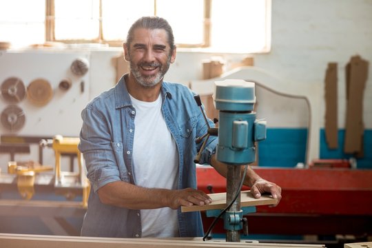 Carpenter using machinery in workshop