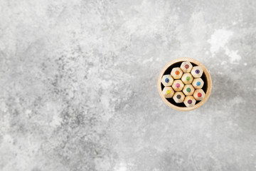 Accessories to drawing - colored pencils on a gray background. Top view, copy space