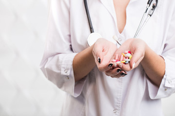 Closeup of a woman doctor holding colorful pills in his hands