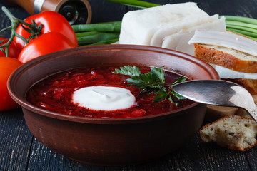 Borscht, vegetarian beetroot soup and ingredients on dark background, close up view