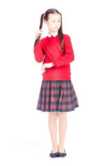 Asian female elementary student in school uniform posing on white background