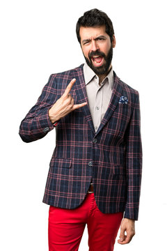 Well dressed man making rock gesture on white background