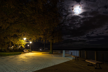 Bench in the park under moonlight and poles.