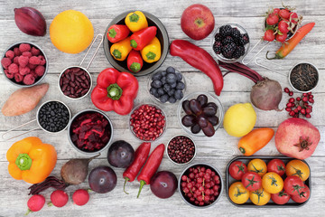 Healthy eating super food concept with fruit, vegetables, pulses and grains very high in anthocyanins, antioxidants, minerals and vitamins on rustic wood background. Top view.