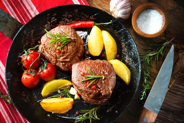 Juicy medium beef fillet steaks mignon in pan on table