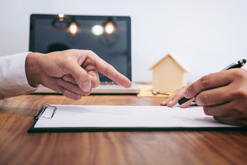 Obraz premium Confident man signing contract of loan agreement document with broker agent, Real Estate concept