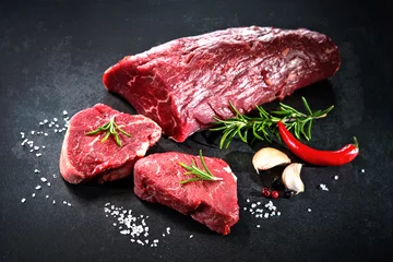 Foto op Plexiglas Whole piece of tenderloin with steaks and spices ready to cook on dark background © Alexander Raths