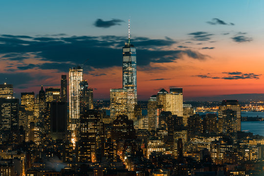 View of modern cityscape with One World Trade Center at dusk