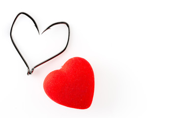 Fishing hooks in the shape of heart and red heart on a white background.