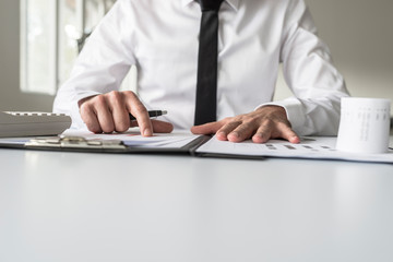 Low angle view of a businessman pointing to an analytical graph