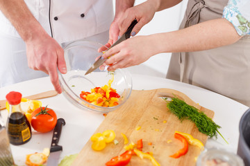Obraz na płótnie Canvas A woman is preparing a salad led by a professional chef.