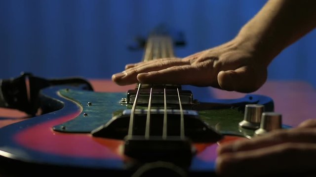 Guitarist nostalgic touch strings of his old bass guitar