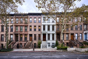 a view of a row of historic brownstone buildings in an iconic neighborhood of Manhattan, New York City