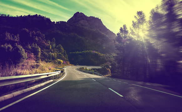 Concepto de viajes por carretera.Carretera de monta&ntilde;a con curvas y puesta de sol.Seguridad y precauci&oacute;n conduciendo.