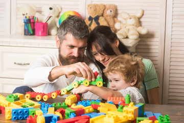 Obraz premium Parenthood concept. Family playing with plastic blocks.