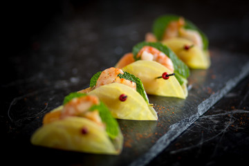 shrimp appetizers on black plate 