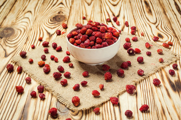 red strawberries in bowl on a wooden background