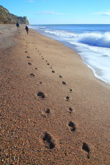 Footprints on the pebble beach in Branscombe, Devon