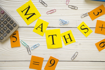 Maths concept on white wooden background