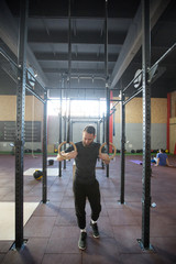 Athlete man with a beard exercising in a crossfit gym