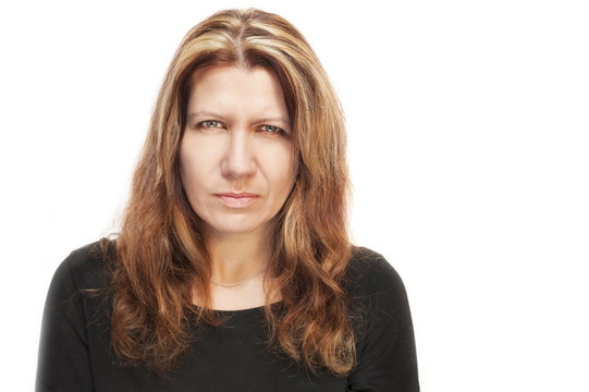 Portrait Of A Middle-aged Woman On A White Background. She Has A Serious Sad Focused Face