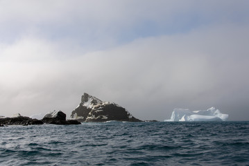 Fototapeta na wymiar Rock with snow in sea