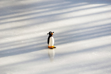 A figure skating ring and a plastic penguin on top of the ice piste