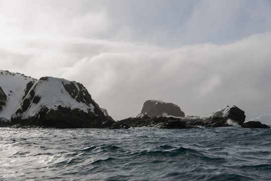 Rock with snow in sea