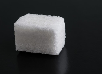 Single Cube of Sugar Isolated on Black Background.