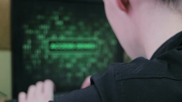 The computer user tries to remember the password. Handheld shot. Cinematic look