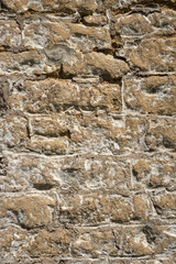 An old previously painted weathered stone wall needs repairs. Construction full frame texture background.