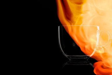 Empty glass mug for tea in the fire flames.