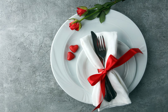 Festive table setting for Valentine's Day with fork, knife and rose